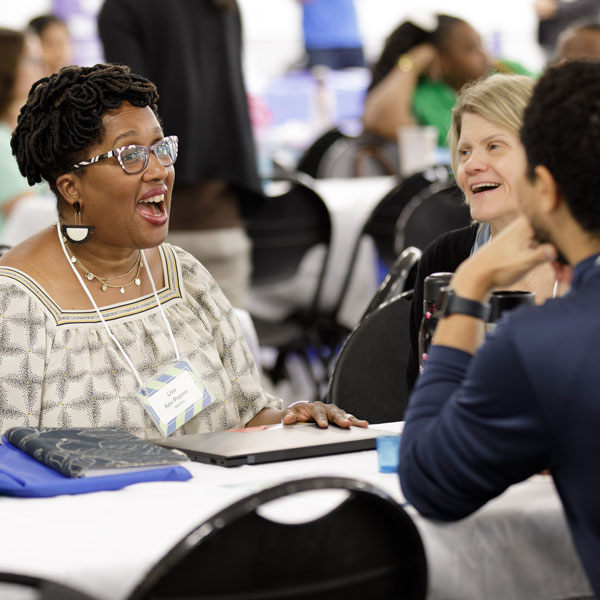 three people at a table talking
