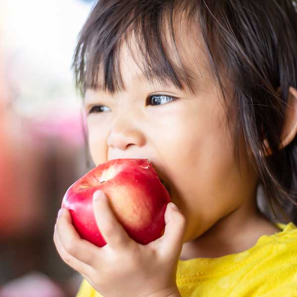 young girl eating an apple