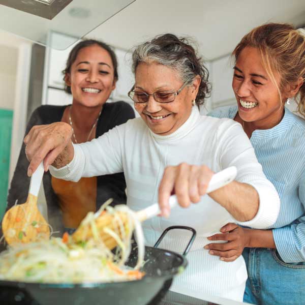 mother cooking with two adult daughters
