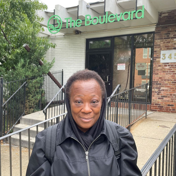 Woman in front of a door with a sign that says The Boulevard