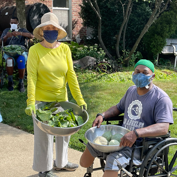 Woman in a sun hat with a man in a wheelchair